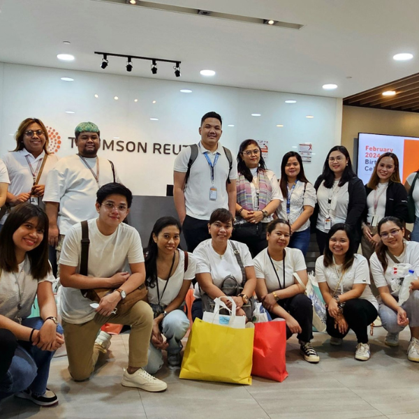 A large group of teammates pose for a photo together in the Thomson Reuters lobby inside the Manila office.